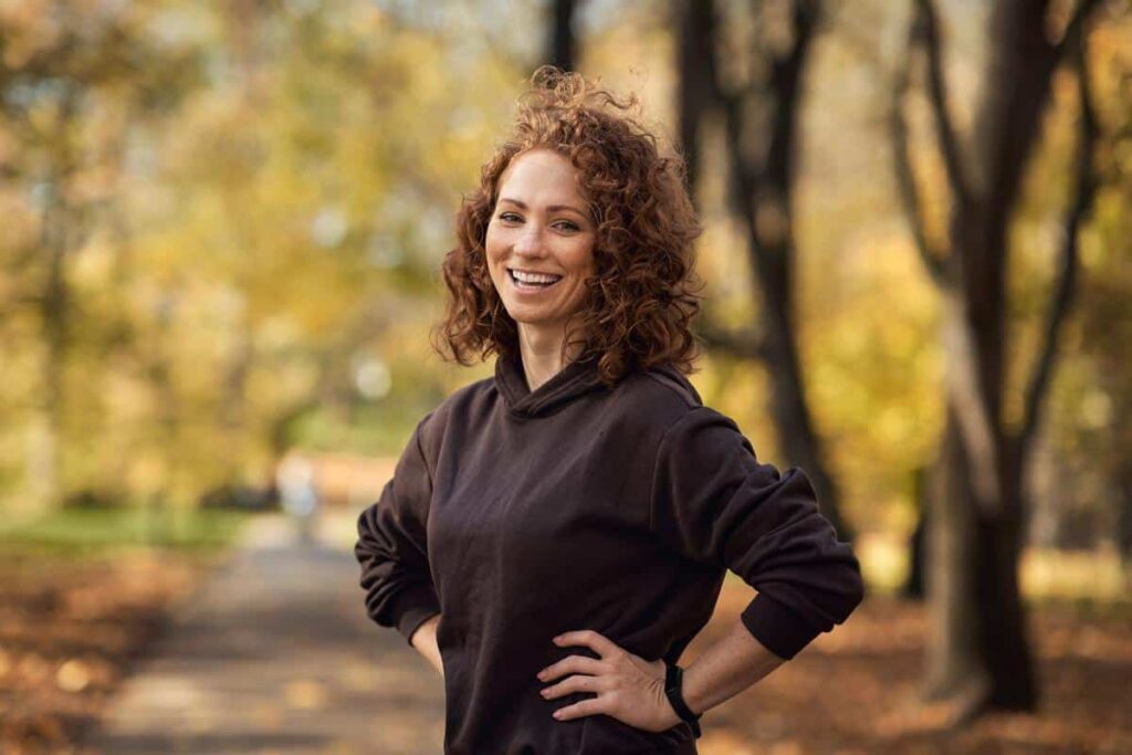 Happy-woman-outdoors-active-smiling Woman smiles outside nature exercise