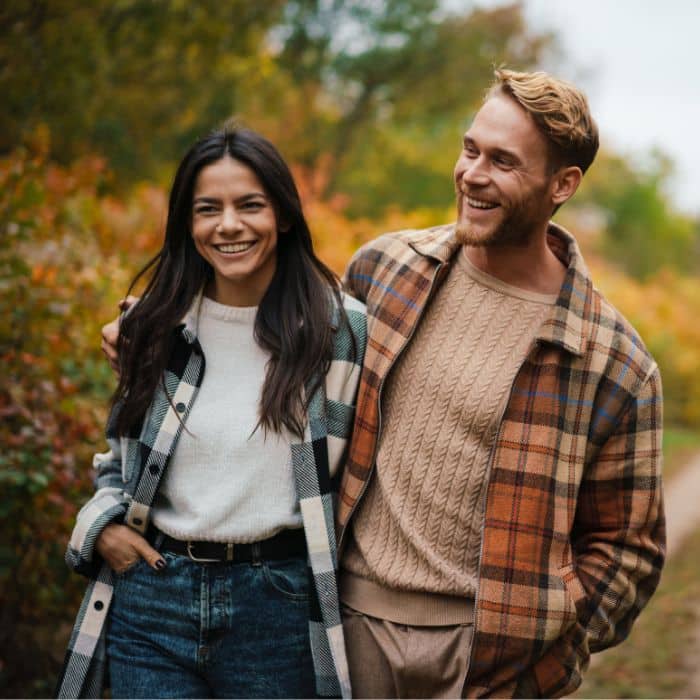 Smiling-couple-walking-outside Happy couple wearing flannel walking outdoors