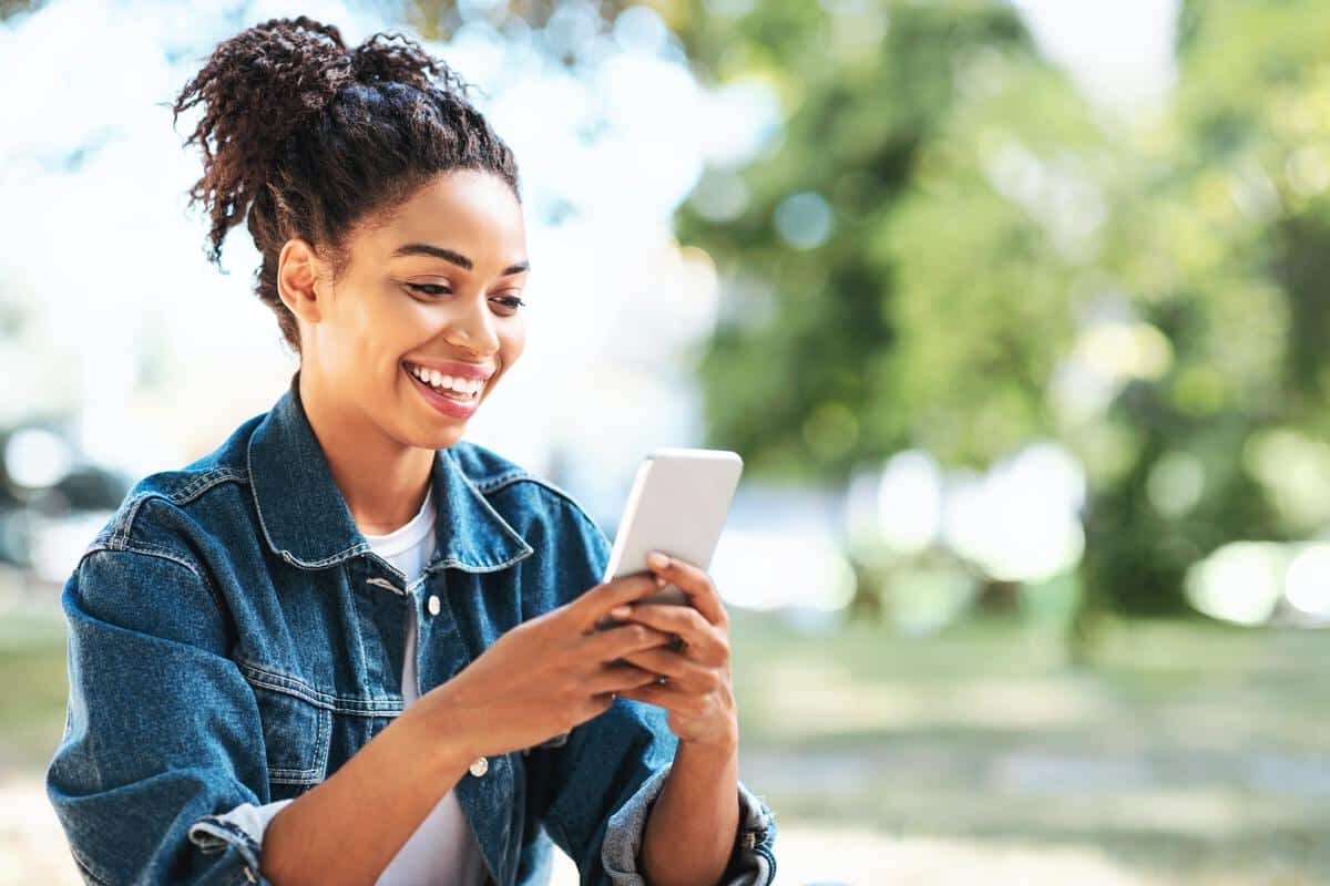Smiling-woman-outside-phone-happy Smiling woman outside happily on her phone