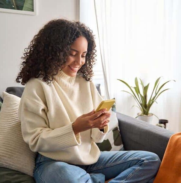 Young-woman-looking-phone Woman looking at phone and smiling
