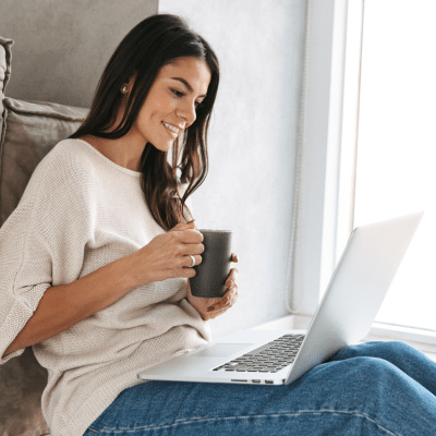 Introducing our new website: experience the zac vance dentistry difference online! 6 Woman on a laptop looking at a website with a cup of coffee in her hands