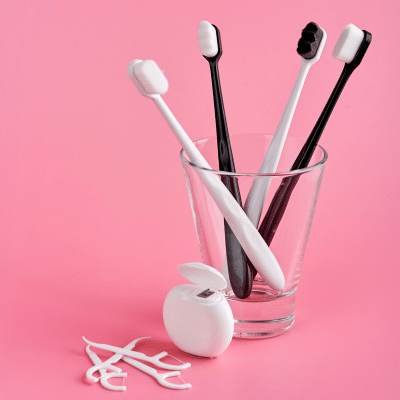 Mastering dental hygiene: brushing and flossing tips 9 Toothbrushes and floss on a pink background, representing dental hygiene