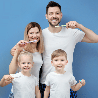 What is family dentistry? Comprehensive care for all ages 1 Family, dad, mom and two kids, all brushing their teeth while wearing white t-shirts on a blue background, representing family dentistry