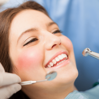 What happens during a routine dental exam? A step-by-step guide 10 A woman smiling at dentist, representing routine dental exam