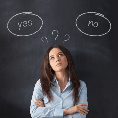 The pros & cons of diy teeth whitening trends 7 A woman standing in front of a chalkboard with question marks above her head and the words yes on one side and no on the other, representing diy teeth whitening