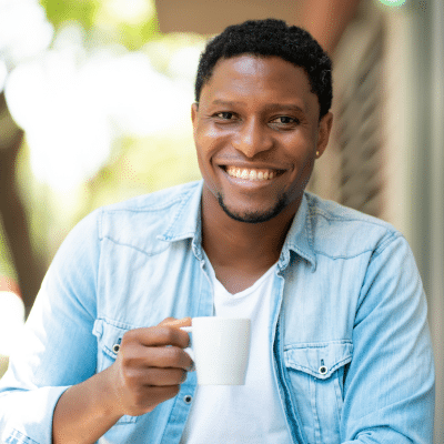 How everyday foods and drinks affect tooth color 1 Smiling man holding a coffee cup, representing how to remove food stains from your teeth